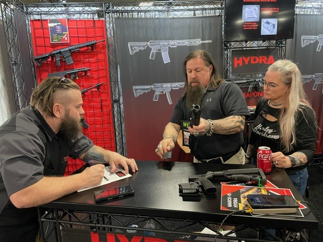 TANNER SMART, HYDRA WEAPONRY'S NATIONAL SALES MANAGER, WRITING ORDERS AT THE BOOTH.